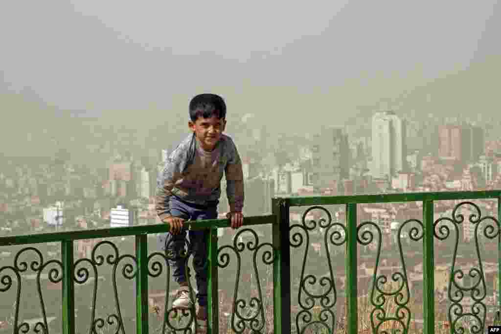A boy plays outside during a heavy sandstorm in the north of Iran&#39;s capital, Tehran, on May 17.