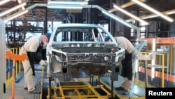 Russian employees work at the assembly line of the Lada Izhevsk automobile plant, part of the Avtovaz Group, in Izhevsk.