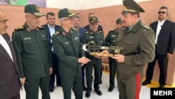 2022-жылдын 17-майы. Ирандын Куралдуу күчтөрүнүн ошол кездеги башкы командачысы Мохаммад Багери жана Тажикстандын ошол учурдагы коргоо министри Шерали Мирзо дрон чыгаруучу заводдун ачылышында деп жарыяланган сүрөт.