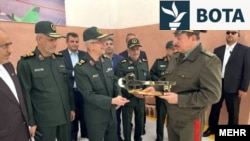 Komandanti i atëhershëm ushtarak i Iranit,  Mohammad Baqeri, dhe ministri i atëhershëm i Mbrojtjes i Taxhikistanit, Sherali Mirzo, gjatë ceremonisë së hapjes së asaj që pretendohet të jetë fabrika iraniane e dronëve në Tajikistan më 17 maj të vitit 2022.