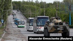 Автобусы с украинскими военными уезжают под конвоем пророссийских военных, 17 мая 2022 года