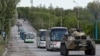 Autobusët duke transportuar ushtarët ukrainas nga Azovstali, nën përcjelljen e makinave të blinduara ushtarake ruse. Mariupol, 17 maj 2022.