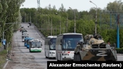 Autobuze cu militari ucraineni de la Azovstal care s-au predat sunt escortate de trupe ale separatiștilor pro-ruși, Mariupol, 17 mai 2022.