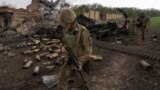 Ukrainian soldiers patrol a recently retaken village north of Kharkiv in eastern Ukraine on May 15.