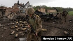 Ukrainian servicemen patrol in a recently retaken village north of Kharkiv on May 15.