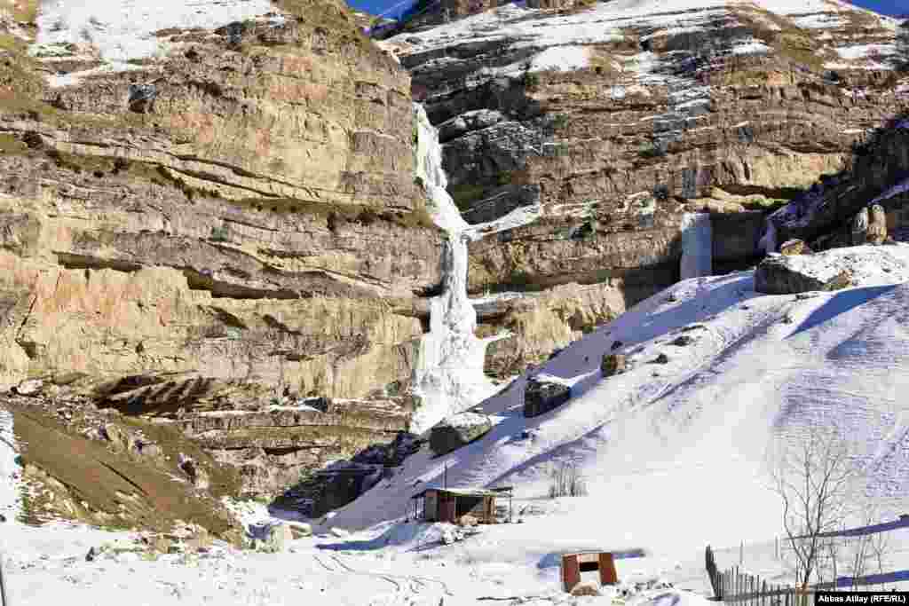 Kəndin yanında buz bağlamış şəlalə.