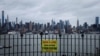 Табличка, напоминающая о важности соблюдения социальной дистанции, на заднем плане - вид на Манхэттен, Нью-Йорк, 3 апреля 2020 года.