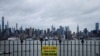 Қашықтық сақтауды ескертіп тұрған тақтайша — арғы бетінде Манхэттен, Нью-Йорк, 3 сәуір 2020 жыл.