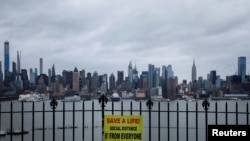 Қашықтық сақтауды ескертіп тұрған тақтайша — арғы бетінде Манхэттен, Нью-Йорк, 3 сәуір 2020 жыл.