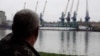 Plauru resident Gheorghe Puflea looks across the Danube at the Ukrainian port of Izmail.