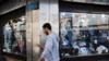 A sign with a depiction of Iran's Supreme Leader, Ayatollah Ali Khamenei, is reflected in a shop window in Tehran