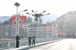 Китайські полісмени піднімають у повітря дрон для моніторингу ситуації на вулицях міста