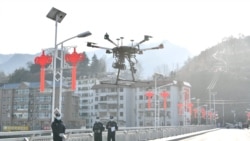 Китайские полицейские поднимают в воздух дрон для мониторинга ситуации на улицах города