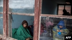 Migranți și refugiați așteptând un tren la granița dintre Serbia și Macedonia de Nord, cu speranța de a ajunge în Germania, în octombrie 2015.