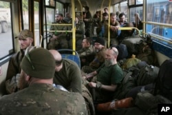 Українські військовослужбовці, які тримали оборону в «Азовсталі», під час перевезення їх автобусом до смт Оленівки, що на Донеччині, 17 травня 2022 року