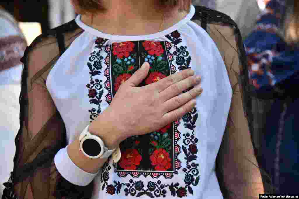 Një grua vendos dorën në zemër teksa mban të veshur një vyshyvanka, një veshje tradicionale, të qëndisur gjatë festimeve të përvitshme të Ditës së Vyshyvankas, në Lviv më 10 maj.