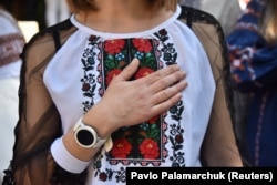 A woman places her hand over her heart as she wears a vyshyvanka, a traditionally embroidered garment in Lviv during the annual Vyshyvanka Day celebration on May 19.