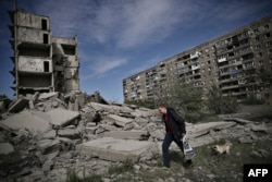Un bărbat merge printre ruinele unui bloc lovit de bombardamente în Kramatorsk, estul Ucrainei.