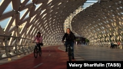 Казахстан, Нур-Султан. Велосипедисты на пешеходном мосту "Атырау"