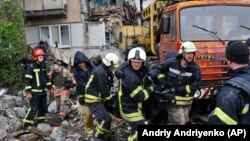 Rescuers carry the body of a civilian at a site of an apartment building that was destroyed by Russian shelling in Bakhmut in the eastern Donetsk region on May 18.