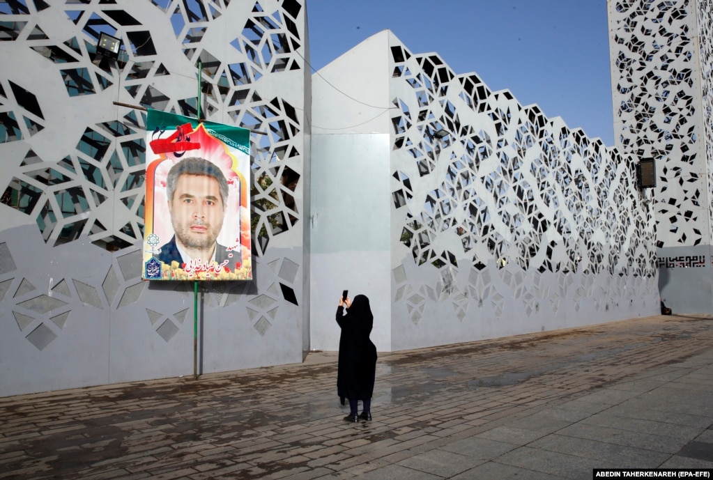 Një grua duke e fotografuar një billbord me portretin e oficerit ushtarak iranian, kolonelin Hassan Sayad Khodaei, i cili u vra në Teheran më 22 maj.