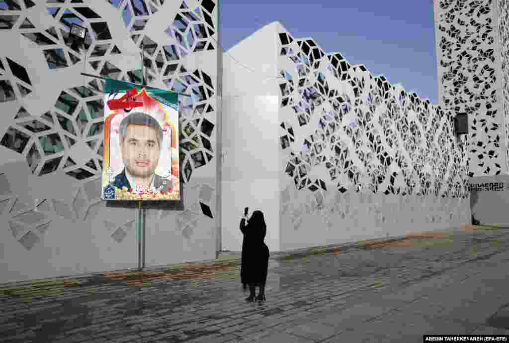 A woman takes a photo of a billboard depicting slain Iranian military officer Colonel Hassan Sayad Khodaei, who was assassinated&nbsp;in Tehran on May 22.&nbsp;