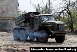 Soldați pro-ruși conduc un sistem de lansare de rachete multiple BM-21 Grad, în orașul Popasna din regiunea Luhansk, Ucraina, 26 mai 2022.