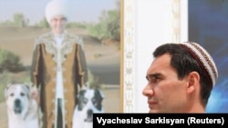 Turkmen President Serdar Berdymukhammedov in front of a portrait of his father, Gurbanguly. (file photo)