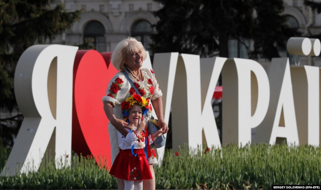 Një grua dhe një vajzë pozojnë për një fotografi në Sheshin e Pavarësisë në Kiev të veshura me vyshyvanka.