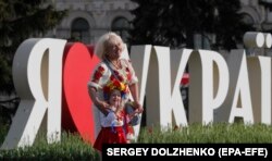 A woman and a girl pose for a photo on Kyiv's Independence Square dressed in their vyshyvankas.