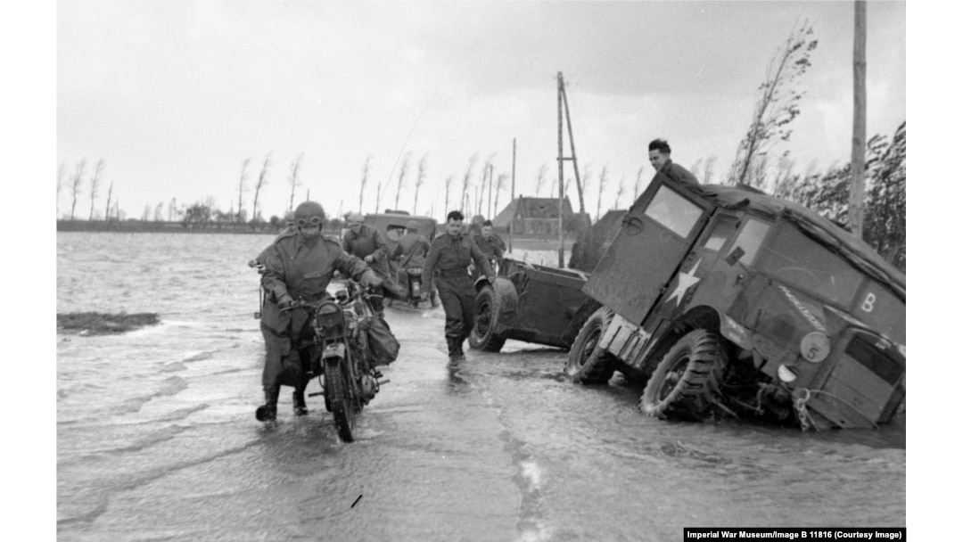 A dispatch motorcycle rider on a flooded road in Holland in November 1944.