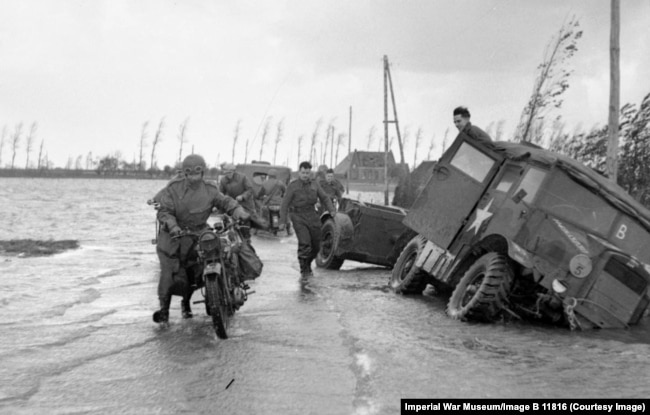 A dispatch motorcycle rider on a flooded road in Holland in November 1944.