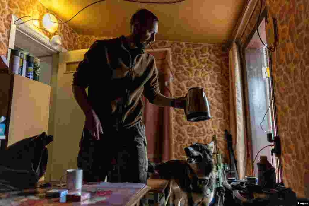 Az ukrán hadsereg egyik katonája pihenőidejében kávét főz nem messze egy tüzérségi állástól a Donyecki régióban