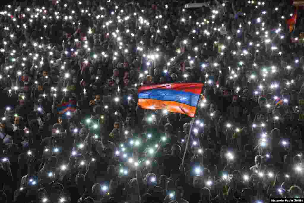 Demonstranti drže mobilne telefone dok marširaju ulicom tokom protesta opozicije u centru Jerevana. Opozicija je protestovala protiv trilateralnog sastanka jermenskog premijera Nikola Pašinijana, predsednika Azerbejdžana Ilhama Alijeva i predsednika Evropskog saveta Šarla Mišela 24. maja u Briselu zbog straha za status regiona Nagorno-Karabaha. &nbsp;