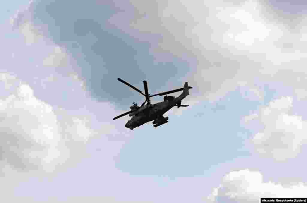 A Russian Ka-52 Alligator attack helicopter flies above the town of Popasna.