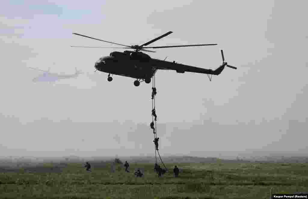 Polish soldiers from the 25th Air Cavalry Brigade rappel down from an Mi-8 helicopter.