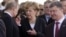 The visit of German Chancellor Angela Merkel (center) to Kyiv this weekend has raised hopes that she may be able to help Russian President Vladimir Putin (left) and Ukrainian President Petro Poroshenko strike a deal that would end the Ukraine crisis. (file photo)