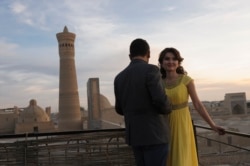 A young couple enjoy a summer sunset near the Kalyan Minaret in Bukhara in 2015.