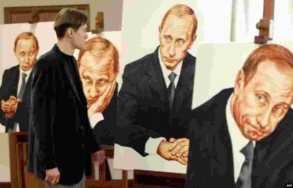 A man looks at portraits of Putin at an exhibition hall in Moscow in 2003.