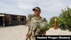 Кыргызский военнослужащий возле сгоревшего пограничного поста в селе Максат Баткенской области. 4 мая 2021 года.