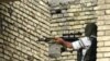 Iraq -- A member of the Imam Al-Mahdi militia aims with his AK-47 during clashes in Al-Basrah, 27Mar2008