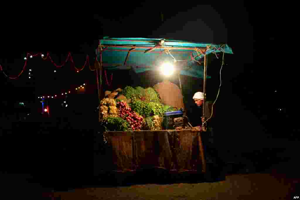 An Afghan fruit vendor waits for customers at a roadside stall in Herat on July 26. (AFP/Aref Karimi)