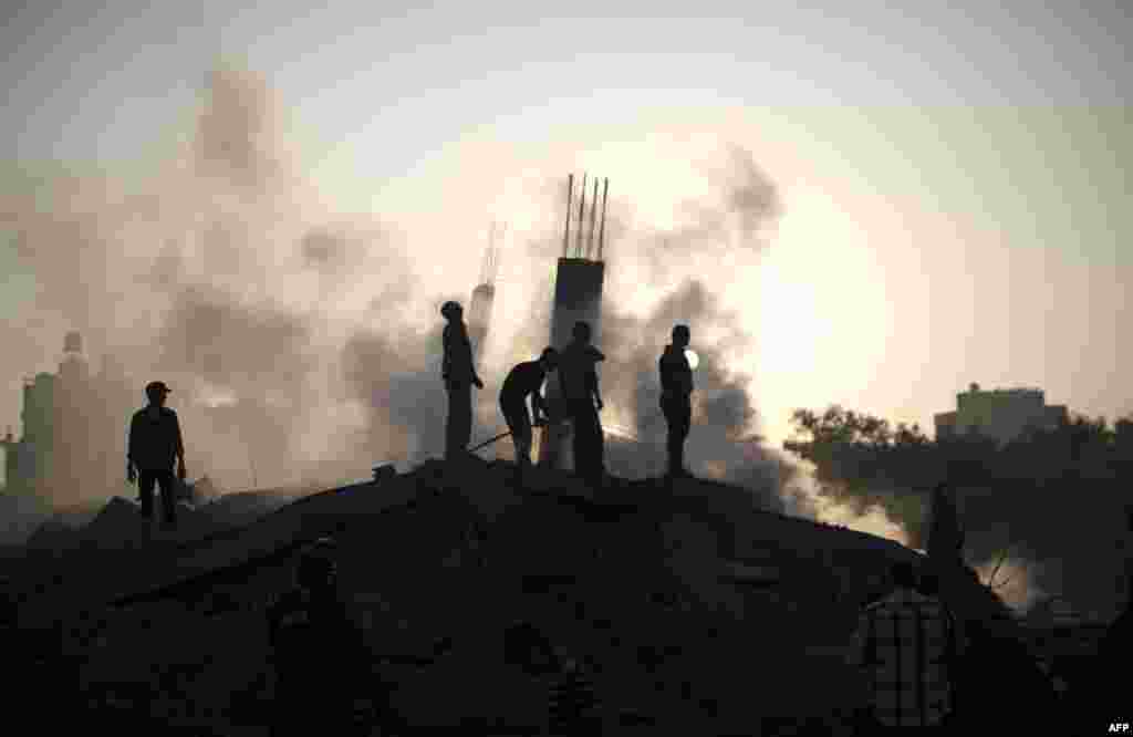 Palestinian men inspect the site of an Israeli military strike in Gaza City on July 8. (AFP/Mahmud Hams)