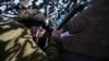 Украинский военный наблюдает за активностью врага на передовой позиции ВСУ вблизи КПВВ «Гнутово», февраль 2020 года. Иллюстрационное фото