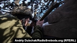 Український військовий спостерігає за активністю ворога на передовій позиції ЗСУ поблизу КПВВ «Гнутове», лютий 2020 року