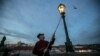 CZECH REPUBLIC -- Lamplighter Jan Tater lights a historic gas lamp on Charles Bridge in Prague, December 18, 2018