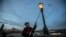 CZECH REPUBLIC -- Lamplighter Jan Tater lights a historic gas lamp on Charles Bridge in Prague, December 18, 2018