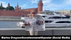 Марина Овсянникова с плакатом: "Путин – убийца, его солдаты – фашисты. 352 ребенка погибли. Сколько еще должно погибнуть детей, чтобы вы остановились?". Москва, 15 июля 2022 года
