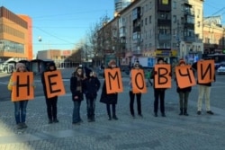 Activists in Dnipro, Ukraine's fourth-biggest city with about 1 million people, hold single-letter posters on November 24 that spell out, "Don't be silent," to protest violence against women.