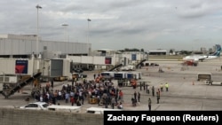 Travelers are evacuated out of the terminal and onto the tarmac after a shooting at the Fort Lauderdale-Hollywood International Airport on January 6.